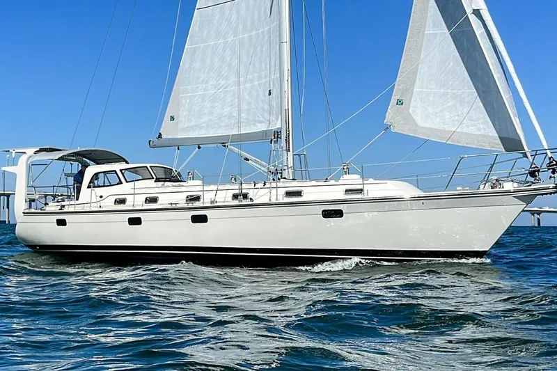  Yacht Photos Pics 2023 Island Packet 439 sailboat cruising on open water under clear blue skies.