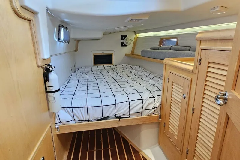  Yacht Photos Pics 2023 Island Packet 439 cabin interior with bed, wooden cabinets, and nautical decor.