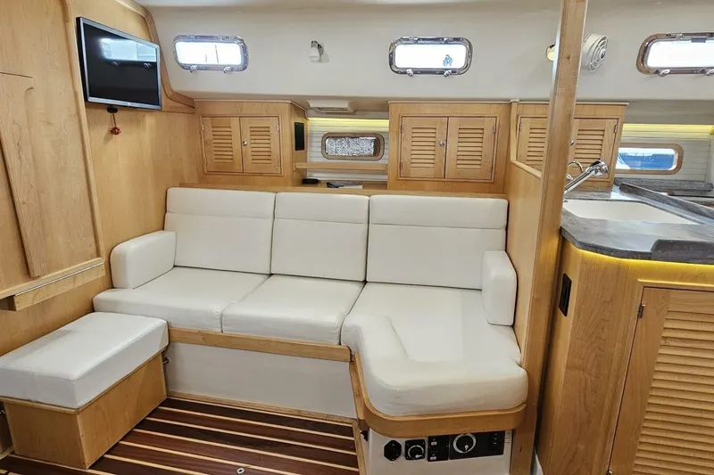  Yacht Photos Pics Interior of 2023 Island Packet 439 yacht with white seating and wooden cabinetry.