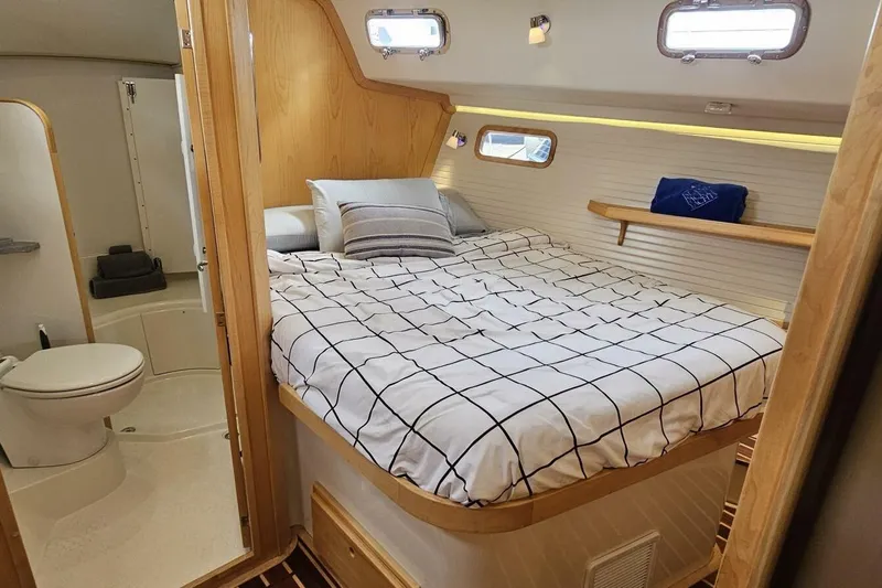  Yacht Photos Pics Cozy cabin interior of 2023 Island Packet 439 yacht with bed and bathroom.