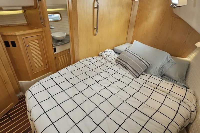  Yacht Photos Pics Luxurious cabin interior of 2023 Island Packet 439 yacht with cozy bed and wooden finish.