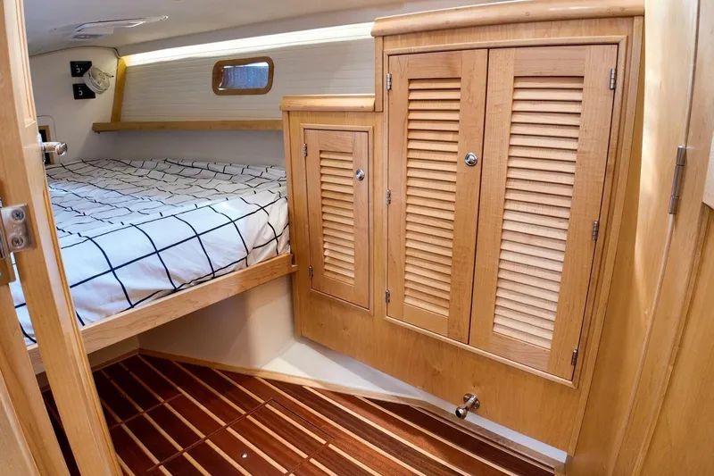  Yacht Photos Pics 2023 Island Packet 439 cabin interior with wooden cabinetry and cozy bed.