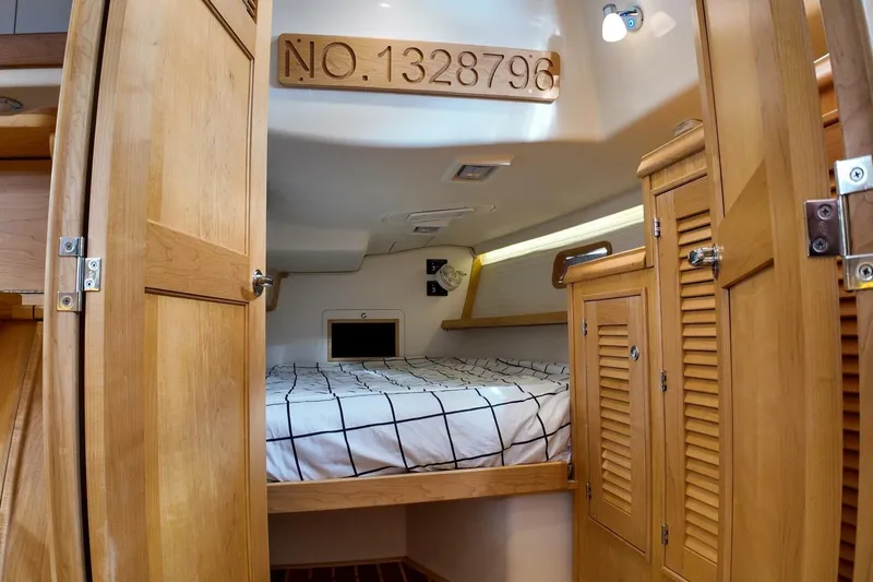  Yacht Photos Pics 2023 Island Packet 439 yacht cabin with wooden interior and bed.