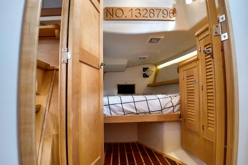  Yacht Photos Pics 2023 Island Packet 439 yacht cabin with wooden interior and cozy bed.