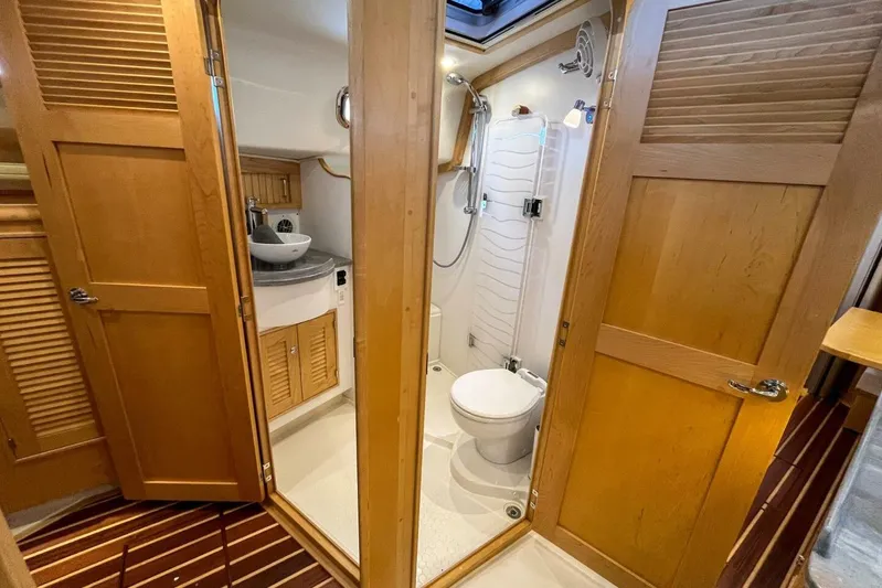 Yacht Photos Pics 2023 Island Packet 439 yacht bathroom with wooden doors, shower, and sink.