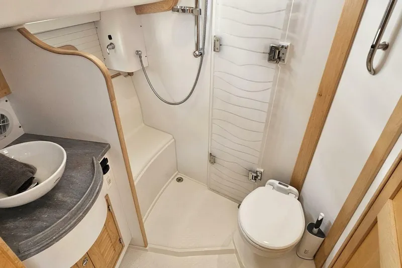  Yacht Photos Pics Modern bathroom in 2023 Island Packet 439 yacht, featuring shower, sink, and toilet.