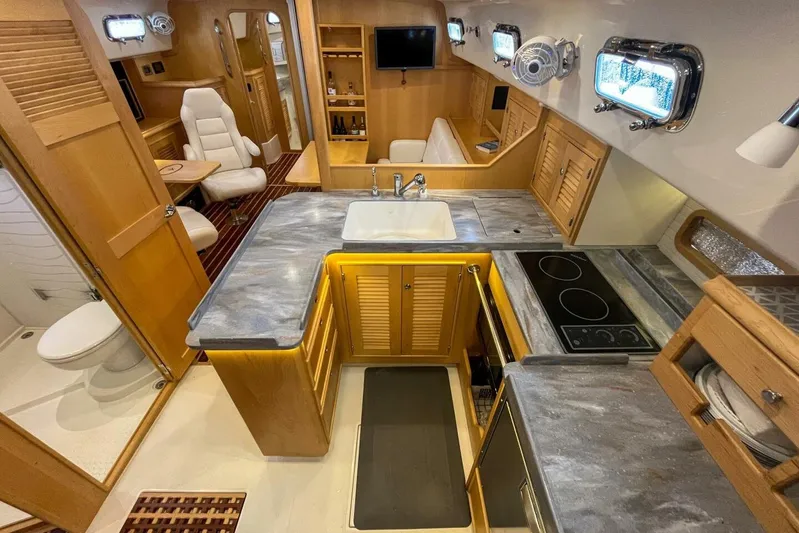  Yacht Photos Pics 2023 Island Packet 439 yacht interior with modern kitchen, seating, and bathroom.