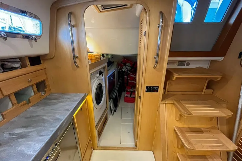  Yacht Photos Pics 2023 Island Packet 439 yacht interior with wooden cabinetry and modern appliances.