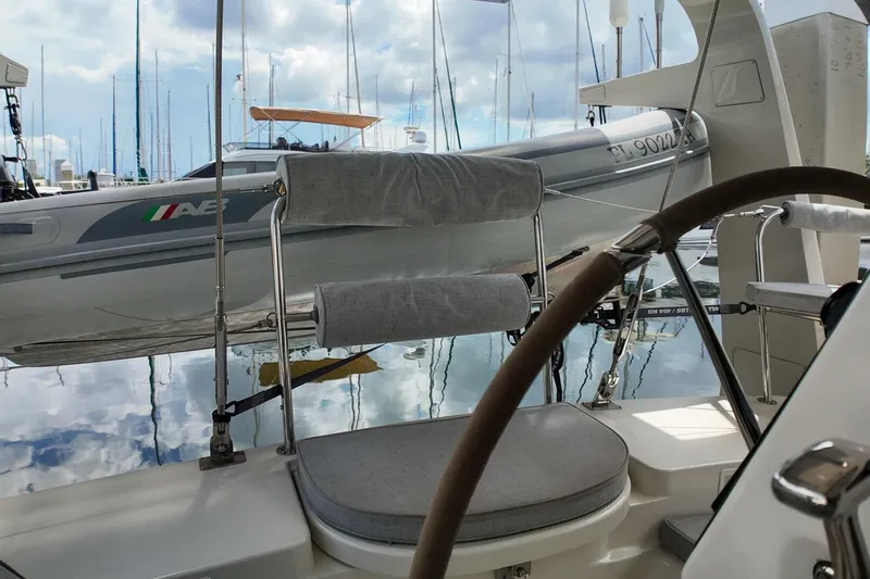  Yacht Photos Pics 2023 Island Packet 439 sailboat cockpit with steering wheel, docked beside inflatable boat.
