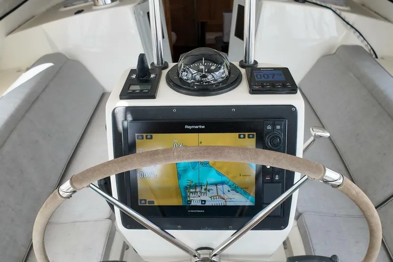  Yacht Photos Pics Steering console of 2023 Island Packet 439 yacht with navigation equipment and compass.