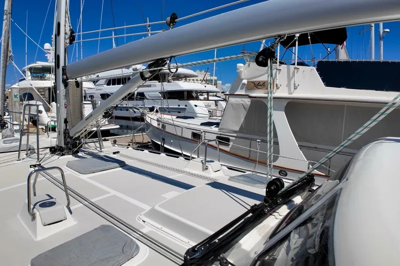  Yacht Photos Pics 2023 Island Packet 439 sailboat docked among luxury yachts in a marina.