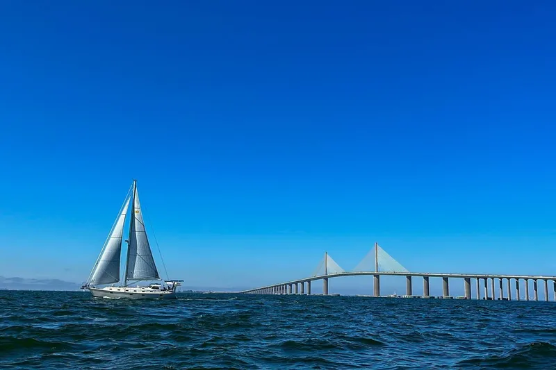  Yacht Photos Pics Sailboat Island Packet 439, 2023 model, cruising near a large bridge under clear blue skies.