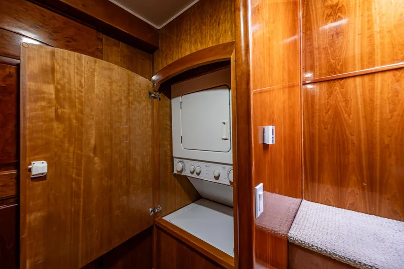 Kell Bell Yacht Photos Pics Laundry area in 2001 Navigator Pilothouse with wooden cabinetry and stacked washer-dryer.