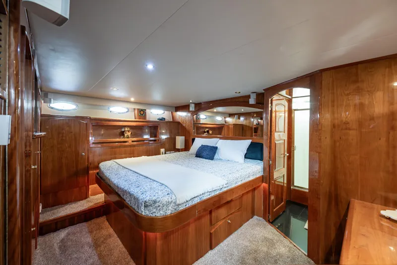Kell Bell Yacht Photos Pics Luxurious 2001 Navigator Pilothouse yacht bedroom with wood paneling and cozy bedding.