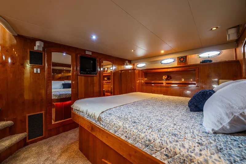 Kell Bell Yacht Photos Pics Luxurious 2001 Navigator Pilothouse yacht bedroom with wood paneling and cozy bedding.