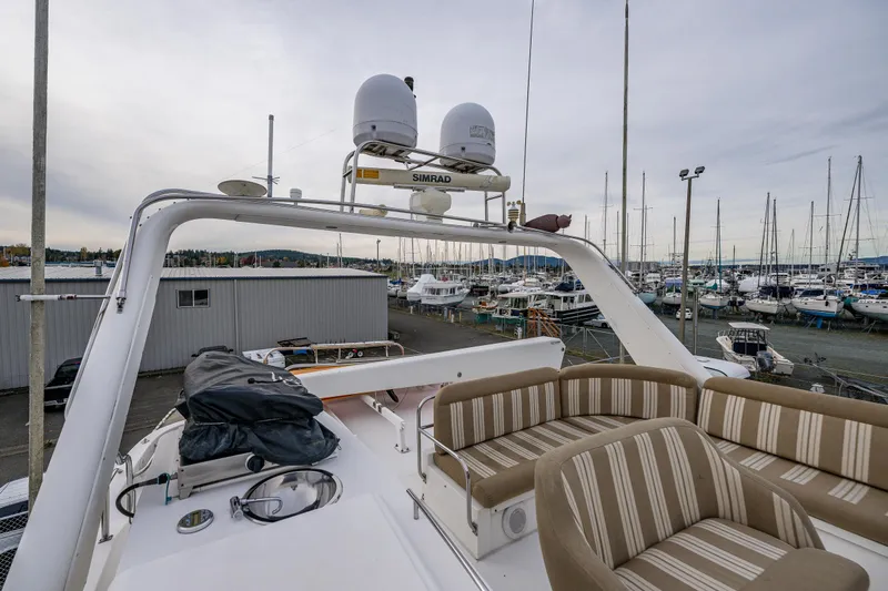 Kell Bell Yacht Photos Pics 2001 Navigator Pilothouse yacht with striped seating, docked in a marina.