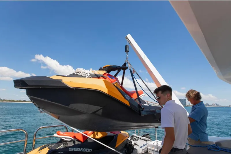 Carpe Diem Yacht Photos Pics Two people securing a jet ski on a 2001 Intermarine RPH 95 yacht deck.
