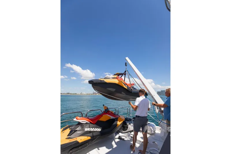 Carpe Diem Yacht Photos Pics Two people loading a Sea-Doo onto a 2001 Intermarine RPH 95 yacht.