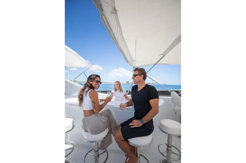 Carpe Diem Yacht Photos Pics People enjoying drinks on a 2001 Intermarine RPH 95 yacht under a sunny sky.