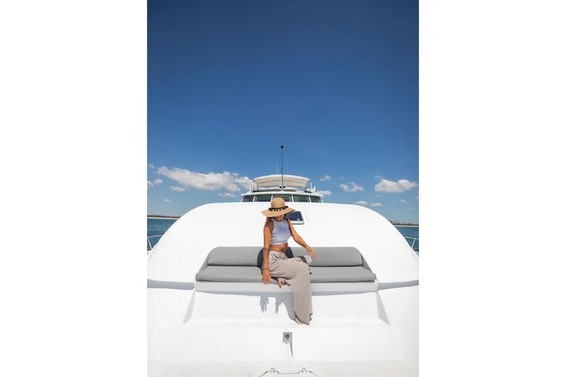 Carpe Diem Yacht Photos Pics Person relaxing on 2001 Intermarine RPH 95 yacht under clear blue sky.