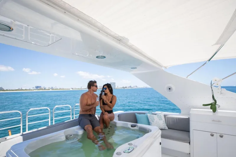 Carpe Diem Yacht Photos Pics Couple relaxing in jacuzzi on 2001 Intermarine RPH 95 yacht, enjoying ocean view.