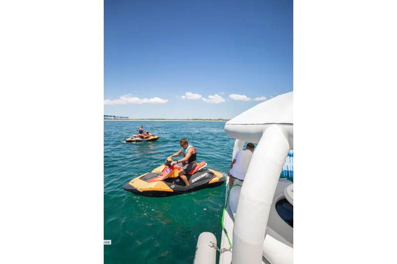 Carpe Diem Yacht Photos Pics Jet skis on clear blue water near an Intermarine RPH 95 yacht, 2001 model.