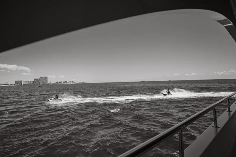 Carpe Diem Yacht Photos Pics View from Intermarine RPH 95 yacht, jet skis on ocean, city skyline in background.