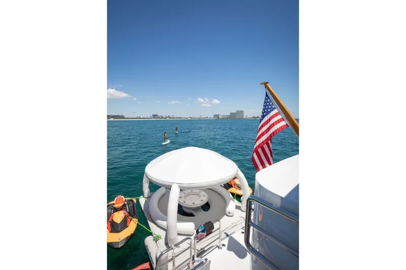 Carpe Diem Yacht Photos Pics Luxury yacht Intermarine RPH 95, 2001, with American flag, ocean view, and paddleboarders.