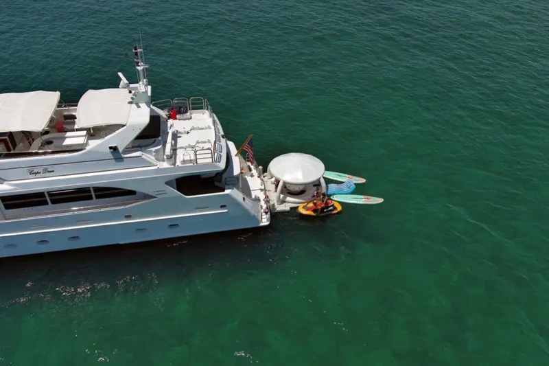 Carpe Diem Yacht Photos Pics Luxury yacht Intermarine RPH 95, 2001 model, anchored with paddleboards in turquoise water.