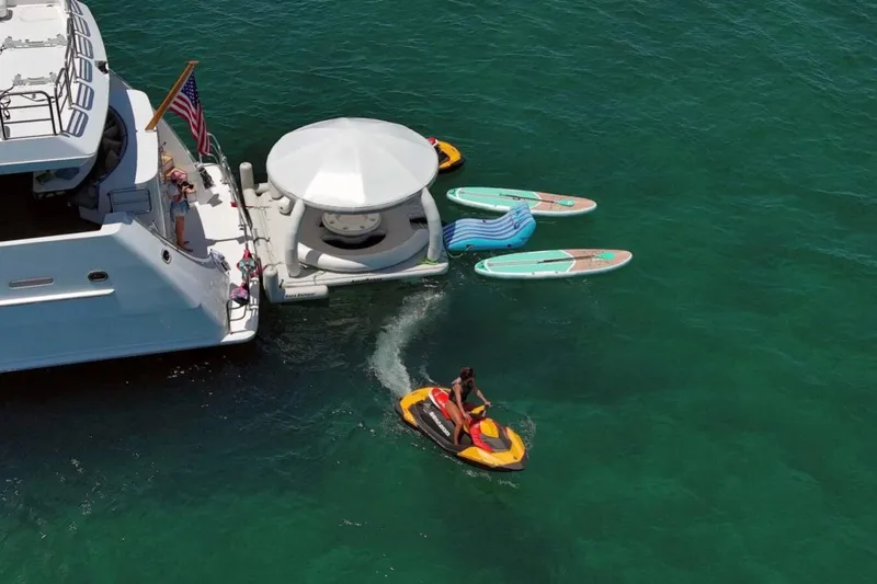 Carpe Diem Yacht Photos Pics Luxury yacht Intermarine RPH 95 with water activities, paddleboards, and jet ski in clear ocean.