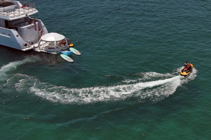 Carpe Diem Yacht Photos Pics Intermarine RPH 95 yacht with jet ski and paddleboards on open water, 2001 model.