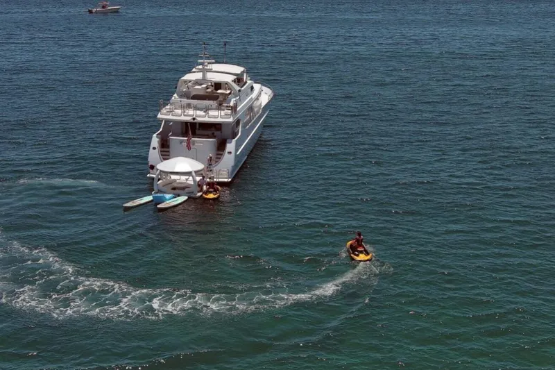 Carpe Diem Yacht Photos Pics Luxury yacht Intermarine RPH 95, 2001 model, with jet ski and paddleboards in ocean.