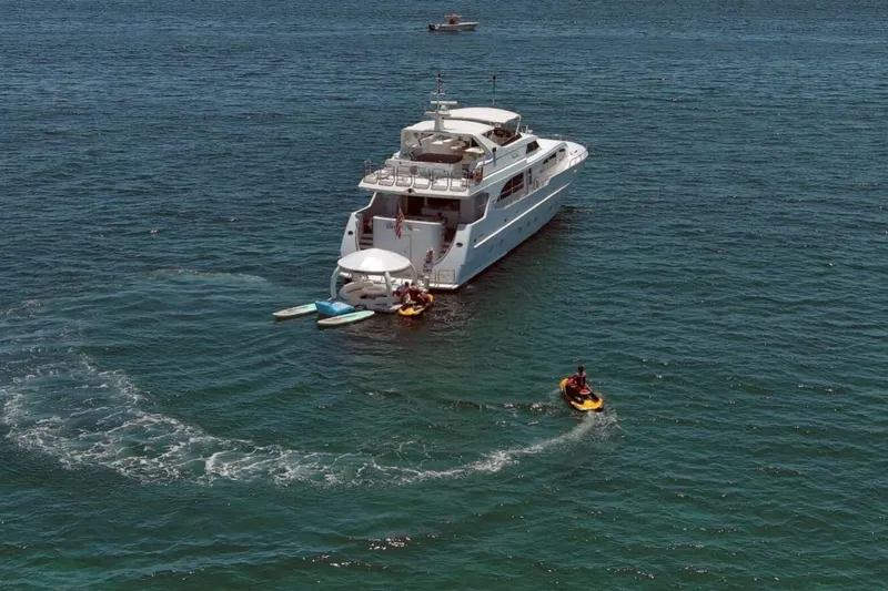 Carpe Diem Yacht Photos Pics Luxury yacht Intermarine RPH 95 (2001) with jet skis and paddleboards on the ocean.