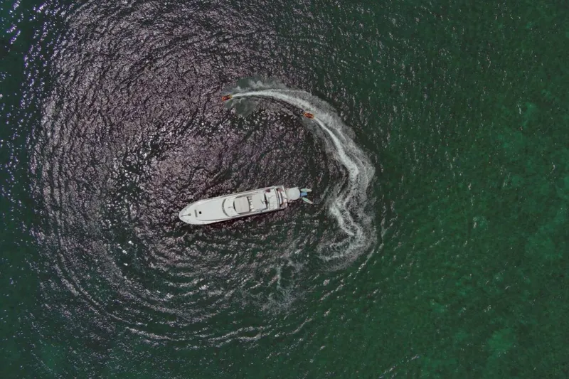 Carpe Diem Yacht Photos Pics Aerial view of 2001 Intermarine RPH 95 yacht on green ocean, creating circular wake.