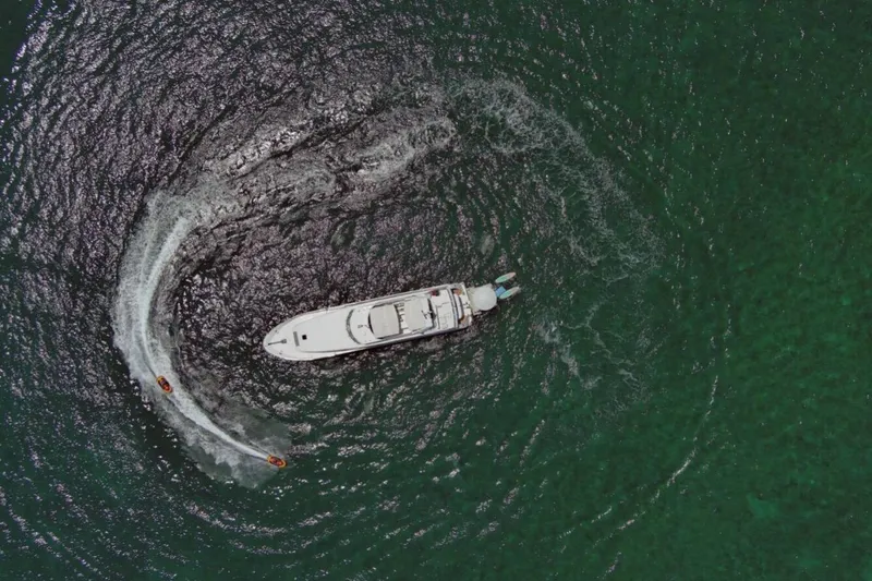 Carpe Diem Yacht Photos Pics Aerial view of 2001 Intermarine RPH 95 yacht with jet skis in green ocean.