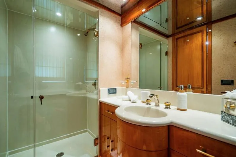 Carpe Diem Yacht Photos Pics Luxurious bathroom on 2001 Intermarine RPH 95 yacht with elegant wood cabinetry and glass shower.