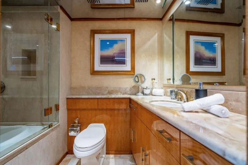 Carpe Diem Yacht Photos Pics Luxurious bathroom on 2001 Intermarine RPH 95 yacht with elegant wood cabinetry and marble surfaces.