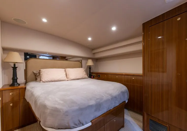 Kraken Yacht Photos Pics Luxurious bedroom interior of 2007 Viking 52 Convertible yacht with cozy bed and elegant wood finish.