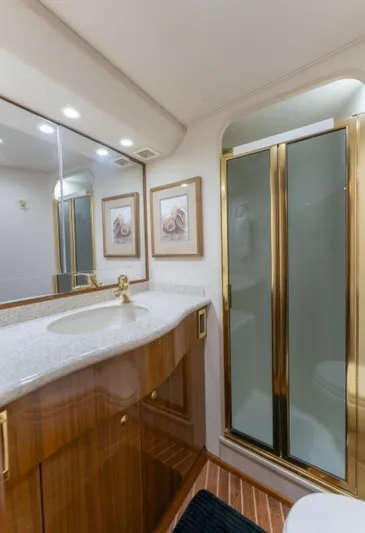 Kraken Yacht Photos Pics Luxurious bathroom in 2007 Viking 52 Convertible yacht with elegant wood cabinetry and glass shower.