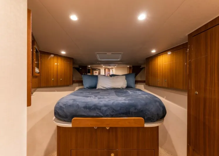 Kraken Yacht Photos Pics Luxurious cabin interior of 2007 Viking 52 Convertible yacht with cozy bed and wooden cabinetry.