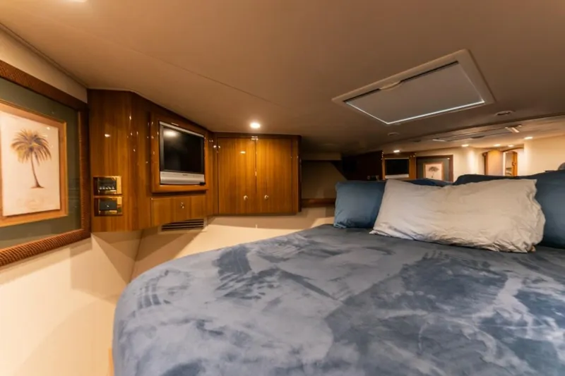 Kraken Yacht Photos Pics Luxurious bedroom interior of 2007 Viking 52 Convertible yacht with cozy bedding and wooden cabinetry.