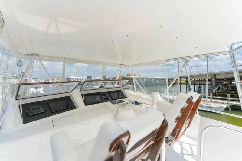 Kraken Yacht Photos Pics 2007 Viking 52 Convertible yacht helm with white seating and panoramic marina view.