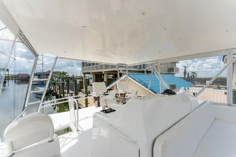 Kraken Yacht Photos Pics 2007 Viking 52 Convertible yacht interior with marina view, featuring sleek white seating and helm.