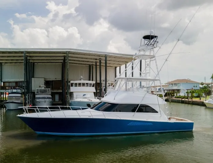 Kraken Yacht Photos Pics 2007 Viking 52 Convertible yacht docked near a marina under cloudy skies.