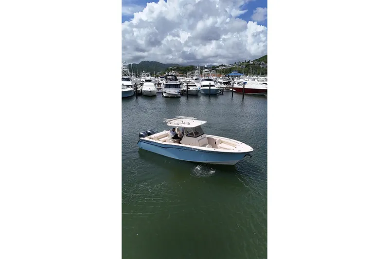  Yacht Photos Pics 2019 Grady-White Canyon 306 boat cruising in a marina under cloudy skies.