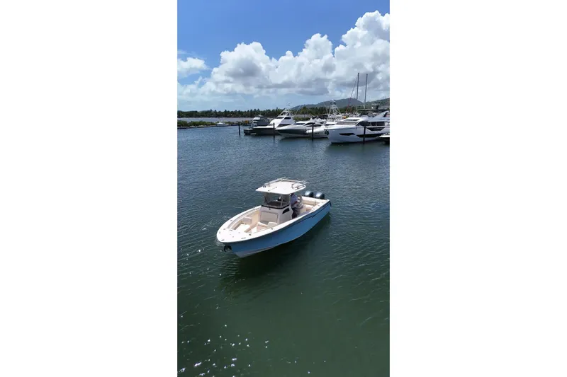  Yacht Photos Pics 2019 Grady-White Canyon 306 boat on calm water near a marina.