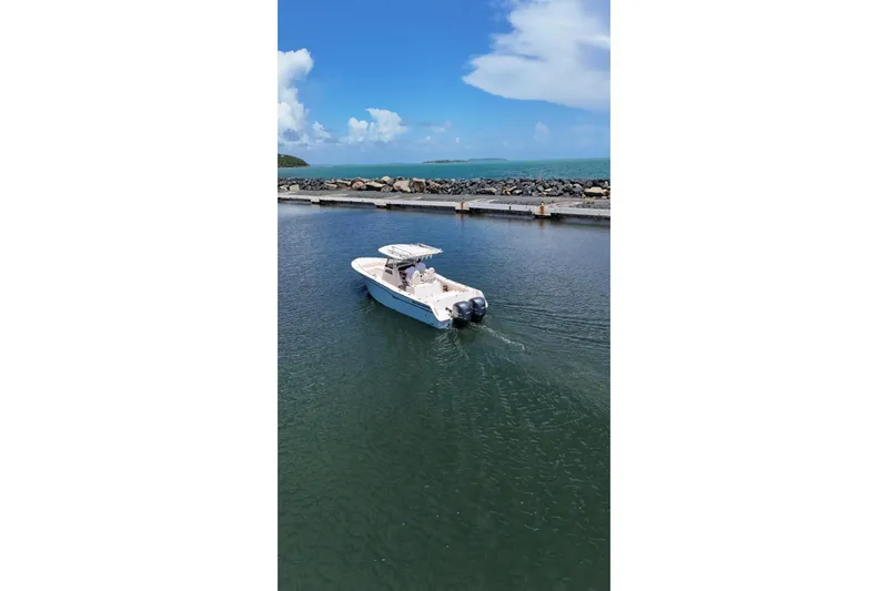  Yacht Photos Pics 2019 Grady-White Canyon 306 boat cruising in a scenic coastal area.