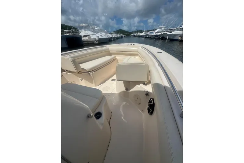  Yacht Photos Pics 2019 Grady-White Canyon 306 boat interior with seating, docked at marina under cloudy sky.