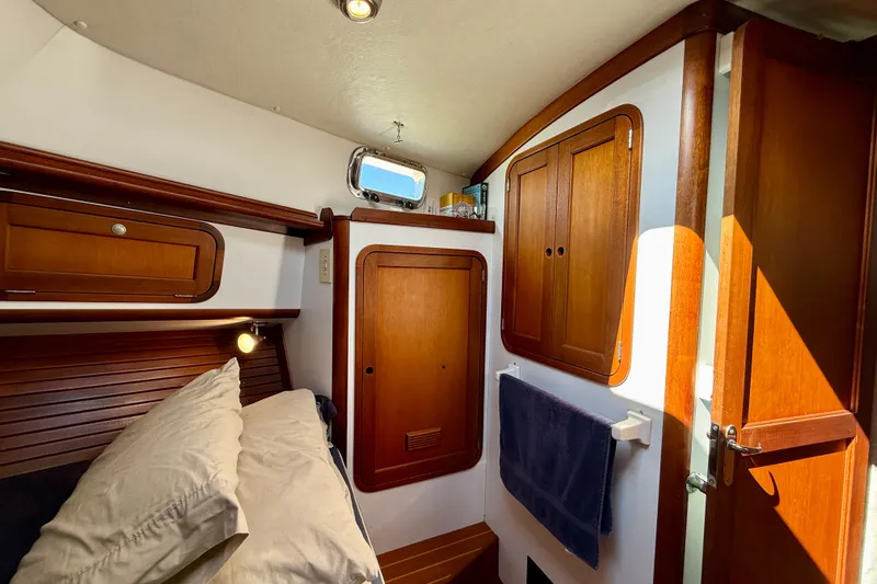 St. Elmo's Fire II Yacht Photos Pics Cozy cabin interior of 1999 Legacy 40 yacht with wooden cabinetry and porthole.