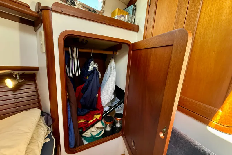 St. Elmo's Fire II Yacht Photos Pics Wooden closet in 1999 Legacy 40 boat cabin, containing clothes and accessories.